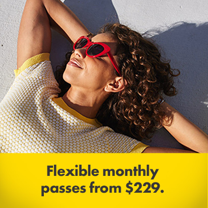 Woman in red sunglasses and yellow t-shirt sunbathing with offer of Flexible monthly passes from $299 at the bottom of the image 